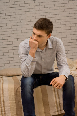 man sitting and thinking looking worried about his cheating girlfriend