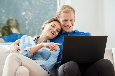 couple cuddling on sofa watching a movie