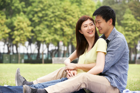 Asian-American couple sitting in the park